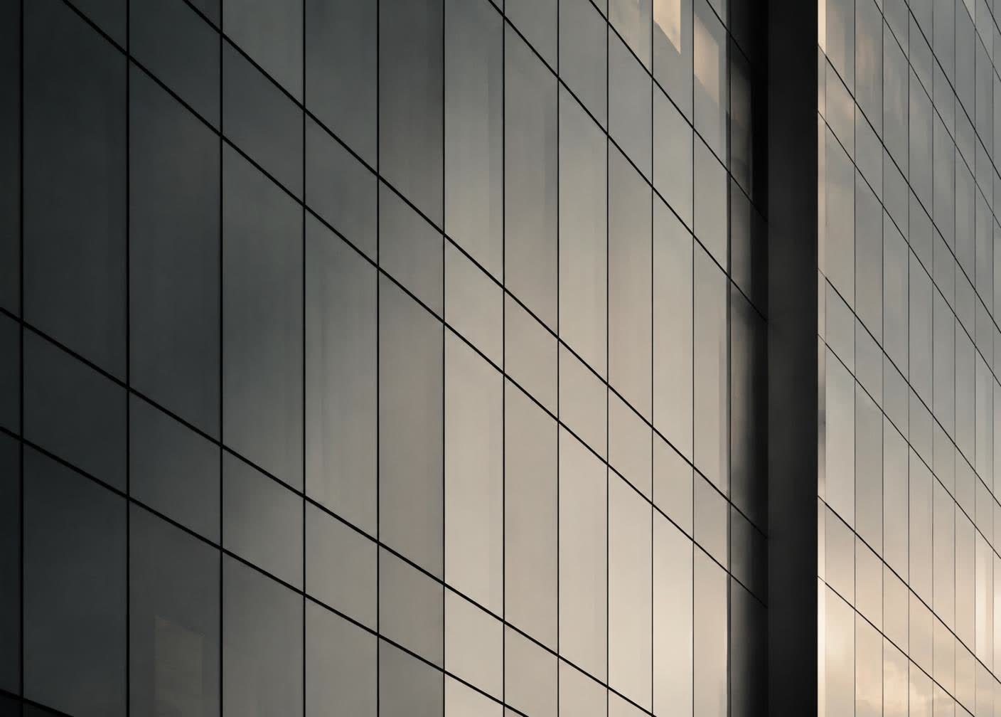 Repeating glass panels on a building facade in soft evening light